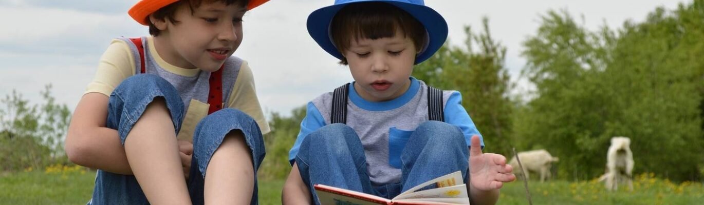 Niños leyendo juntos sentados en un jardín.