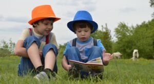 Niños leyendo juntos sentados en un jardín.