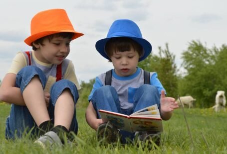 Niños leyendo juntos sentados en un jardín.